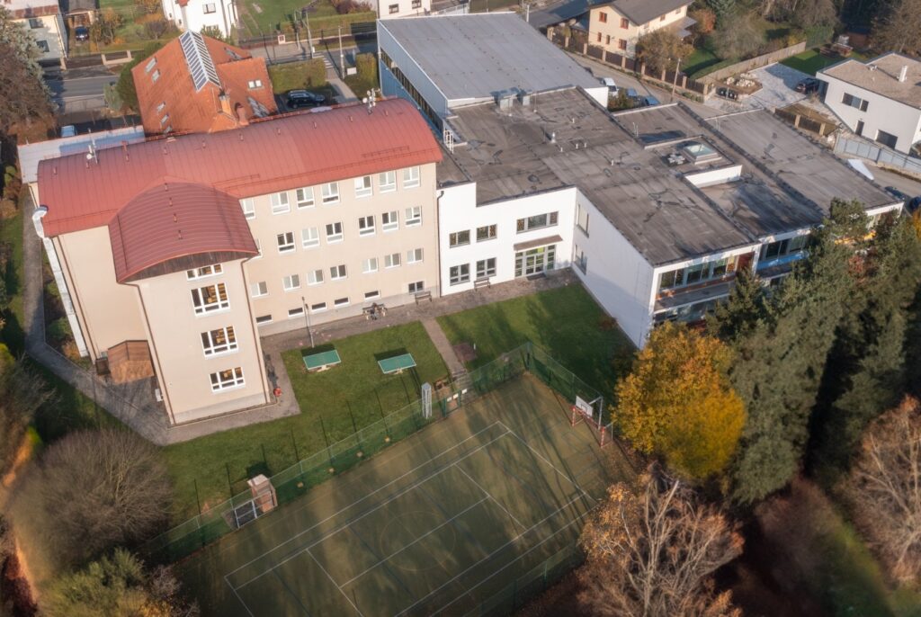 Letecký pohled na budovu ZŠ Strančice se zahradou, hřištěm a tělocvičnou